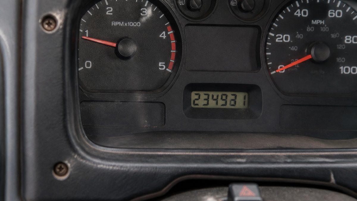 Signs of Odometer Rollback on Trucks: 7 Warning Signs Close-up of a used truck's instrument cluster showing the odometer display, with visible scratches around the dashboard screws and slightly misaligned digits
